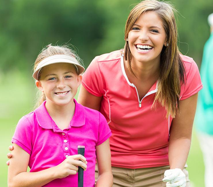 Woman and child holding golf clubs