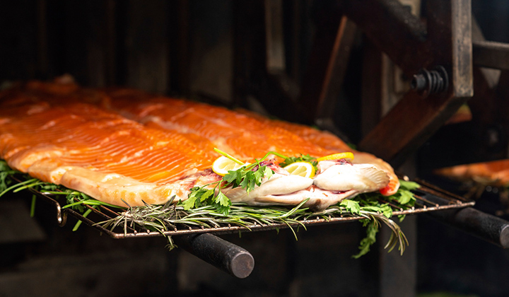 Salmon roasting over a fire at Playing with Fire dinner featuring Chef Nic Webber, Chef Jacob Jordan and Rincon Brewery at The Grill at Torrey Pines in La Jolla.